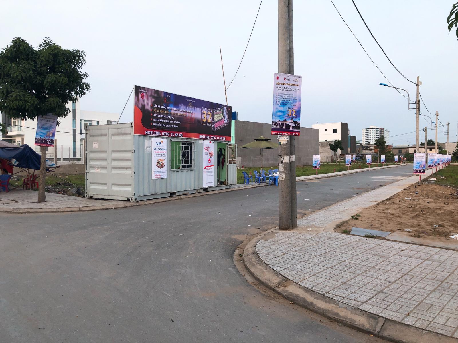 Ảnh chụp một góc con đường với những ngôi nhà, cây xanh và cột điện 2 bên đường