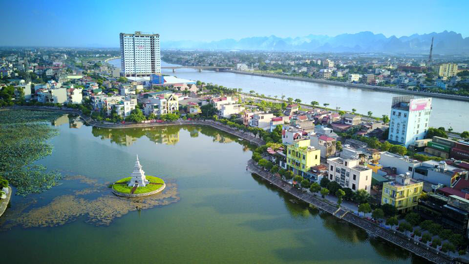 Một góc thị xã Phủ Lý gồm những khu dân cư trải dài cạnh một con sông, tòa nhà chung cư cao tầng phía xa...