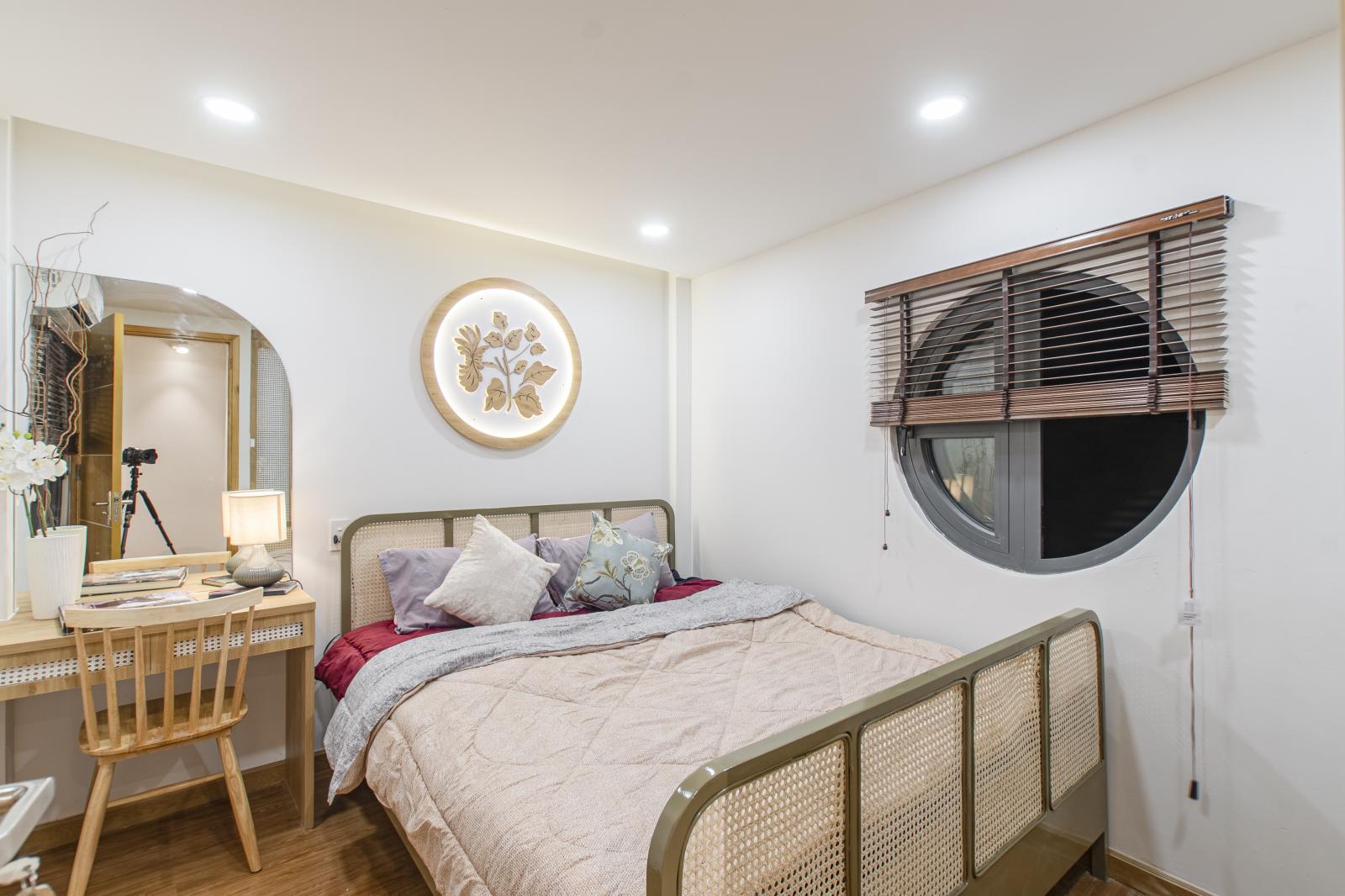 Hai khung cửa tròn trong phòng ngủ giúp lấy sáng từ cả bên trong và bên ngoài. phòng ngủ hiện đại với gam màu trắng