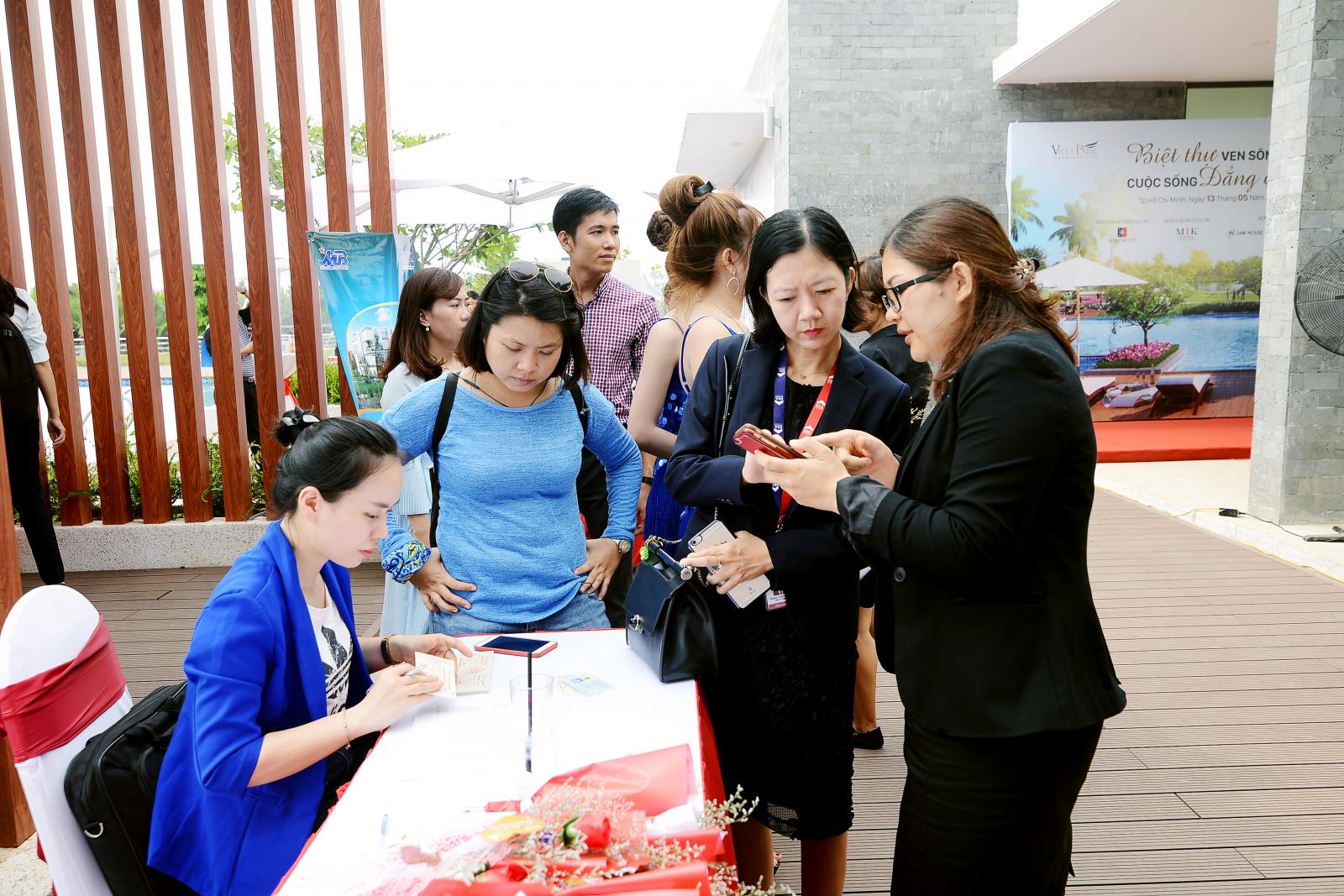 Một nhóm khách hàng và nhà đầu tư bất động sản đang xem thông tin dự án.