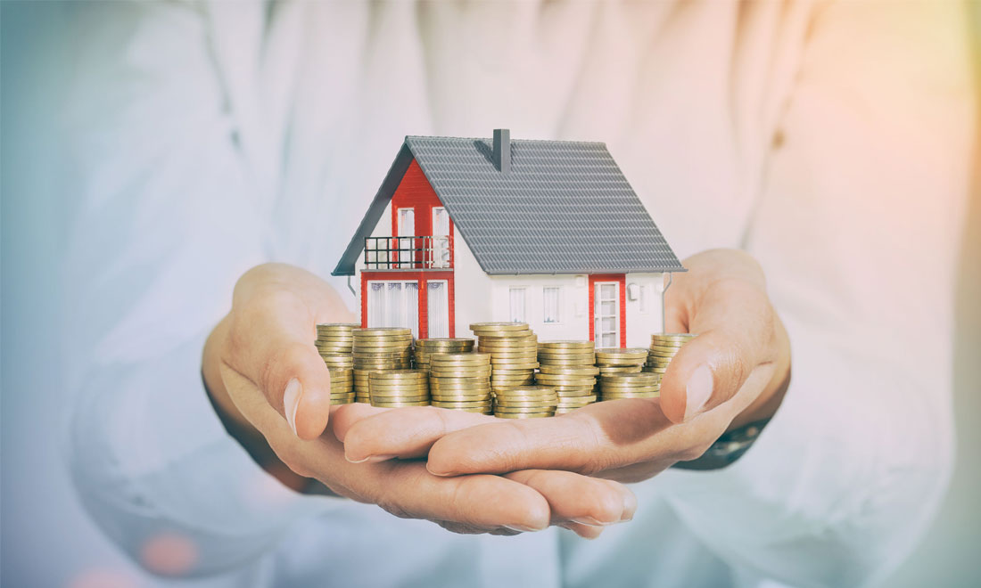 một người cầm mô hình ngôi nhà trên tay