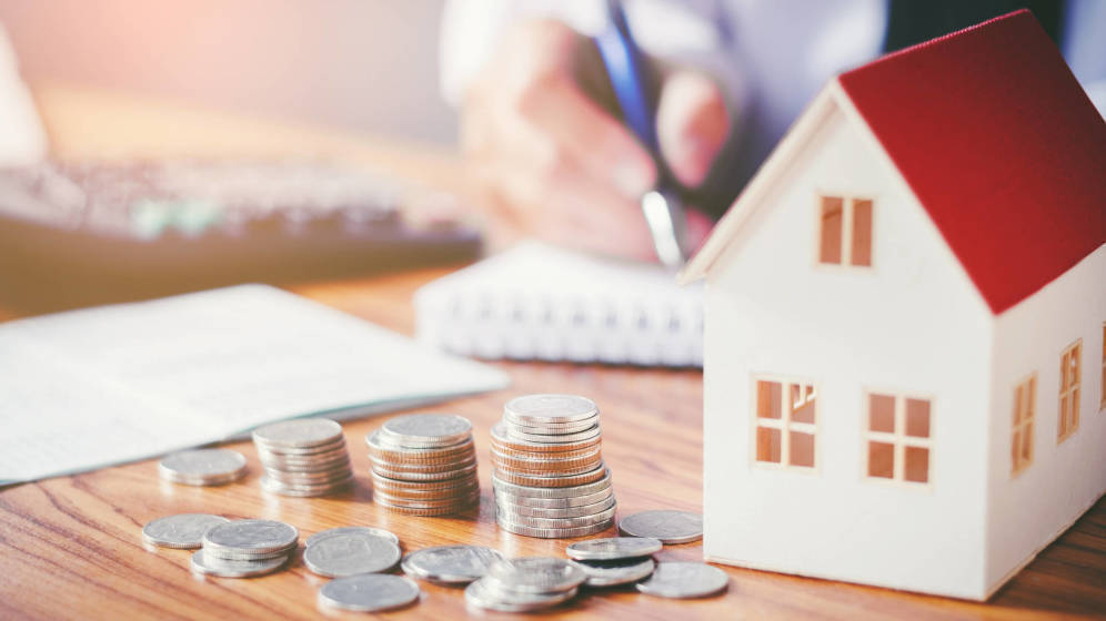 một người đang cầm bút và hình ngôi nhà