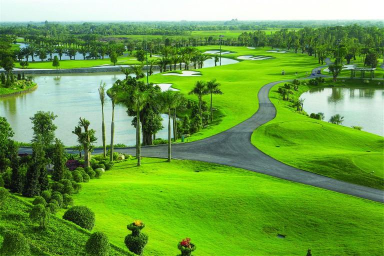 sân golf lớn, nhiều cây cối và hồ nước